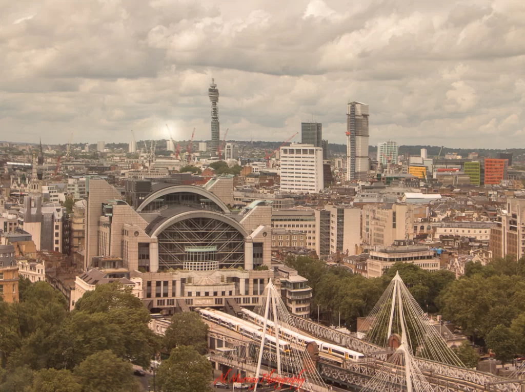 Wide-angle view of central London featuring the modern Charing Cross Station, the BT Tower in the distance, and a train crossing the Hungerford Bridge. This cityscape sets the scene for travellers seeking urban orientation, tying into a guide offering going to Wimbledon tips.