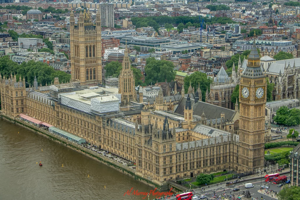 Aerial view of the Palace of Westminster in London, showcasing the iconic Big Ben clock tower, detailed Gothic architecture, and the River Thames running alongside. A classic sightseeing option for visitors wondering what to do on Wimbledon rain days.