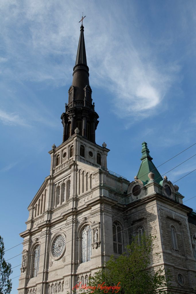 Historic stone cathedral with a stained glass window and twin bell towers stands beneath a clear blue sky in Old Quebec. Visiting landmarks like this offers timeless charm and cultural depth, making it one of the best Quebec City Valentine’s Day ideas on a budget.

