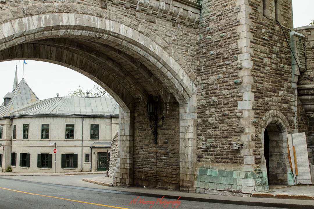 Stone archway of one of Quebec City's historic gates frames a quiet street lined with old-world architecture and muted charm. Exploring landmarks like this on foot is one of the best Quebec City Valentine’s Day ideas on a budget, offering romance without the cost.
