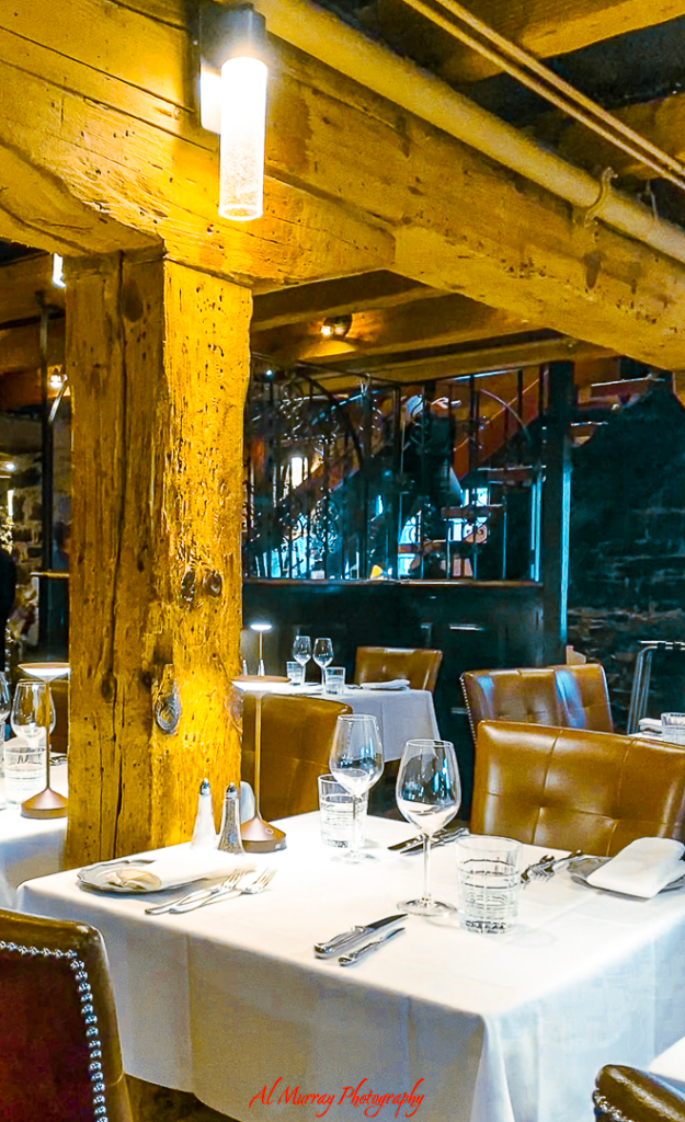 Cozy and intimate restaurant setting in Old Montreal featuring rustic wooden beams, soft lighting, and elegant table settings with wine glasses and leather chairs. This warm ambiance makes it an ideal spot for couples seeking Old Montreal romantic dinner ideas.
A must have on Montreal Valentines' Day Itinerary for Couples
