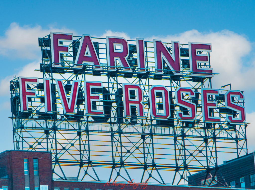 Close-up of the iconic Farine Five Roses sign in Montreal, with bold red letters against a blue sky. This landmark is a symbol of the city’s creative spirit and a favorite photo spot for LGBTQ solo travelers exploring Montreal’s rich culture and industrial charm.