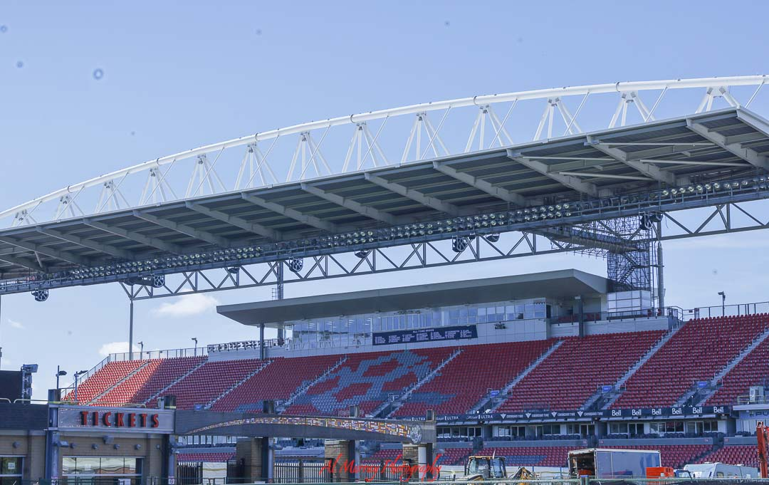 Large outdoor soccer stadium in Toronto with rows of red seats and a modern covered grandstand under a clear blue sky, viewed from outside the ticket entrance. The image highlights one of the main venues for Where to Watch the World Cup 2026 in Toronto, showcasing the scale and atmosphere of a World Cup host stadium.