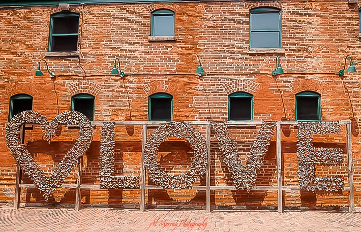 Brick building with large decorative "LOVE" sign made of small objects and a heart shape on the left, creating a calm photo spot that fits quiet things to do in toronto summer.
