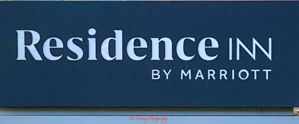 Close up of a dark blue hotel sign reading "Residence Inn" and "BY MARRIOTT". The branding highlights a property type often considered by travellers looking for Toronto hotels with kitchens.