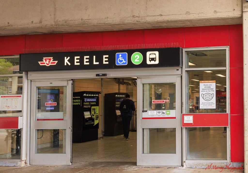 where to stay in Toronto as a solo traveller The entrance to Keele TTC subway station in Toronto with bright red wall panels and open glass doors.